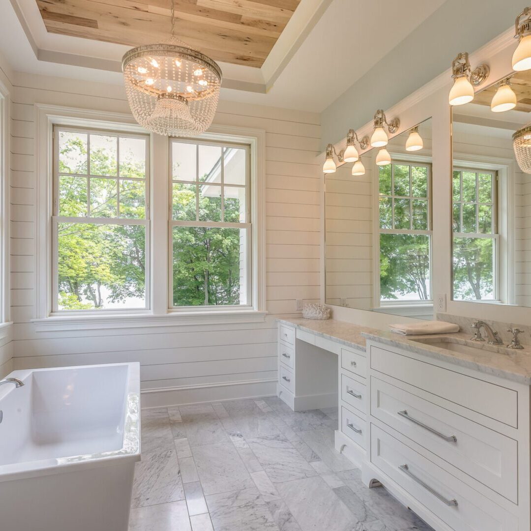 Gorgeous master bathroom with wood tray ceiling Bright bathroom with tub and large windows.