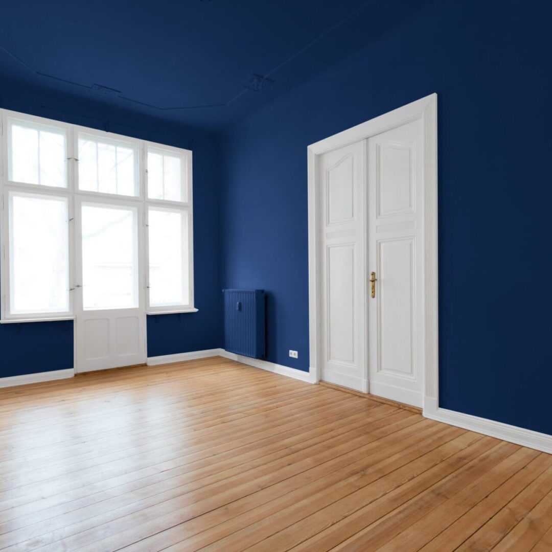 new flat in old building - renovated room Empty room with blue walls and window.